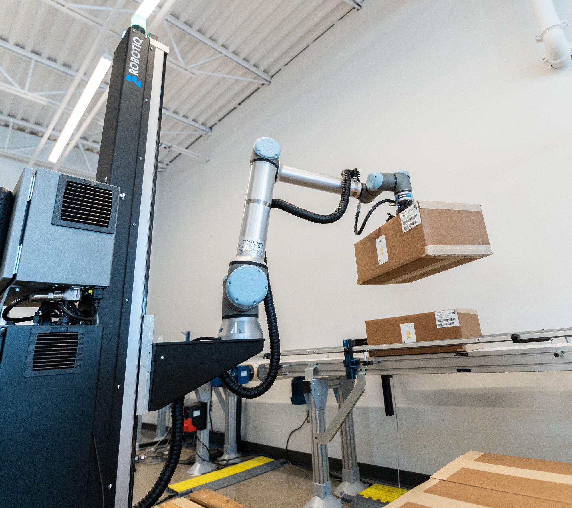 Robotiq Palletizing Solution picking boxes off a production line