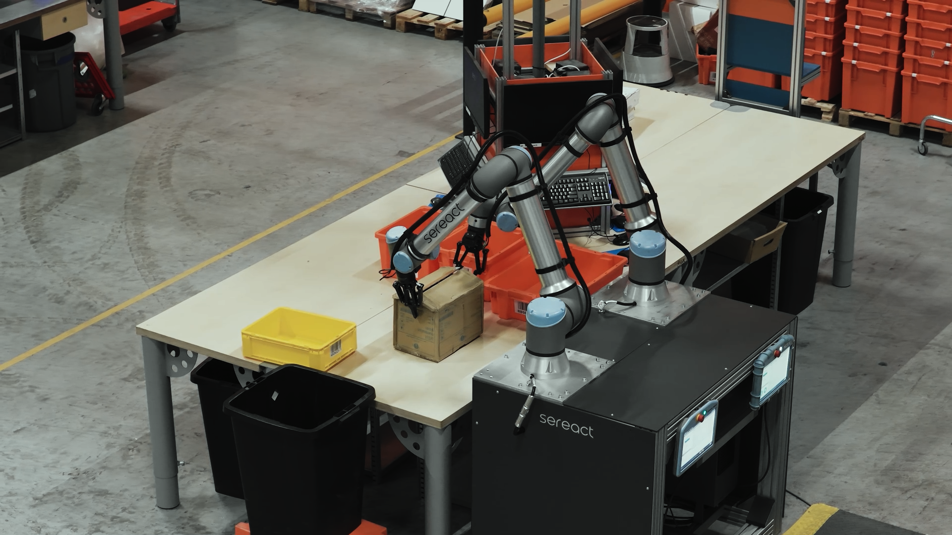 Bimanuelle Sereact-Roboterzelle mit Robotiq 2F-140-Greifern in einem Lager