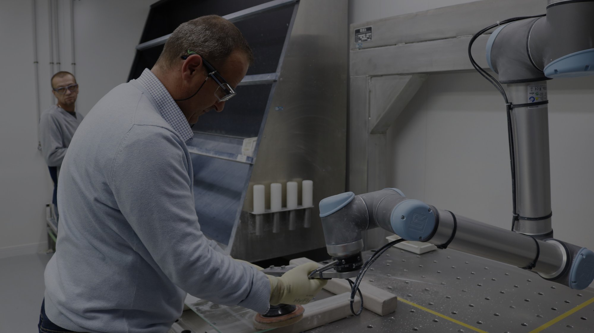 St-Gobain employees working with a Robotiq robot